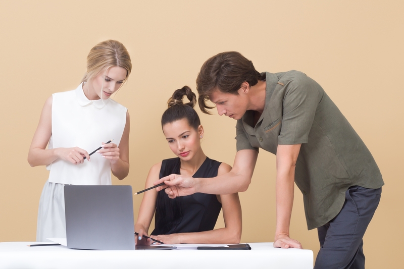 Tre personer arbejder ved computer