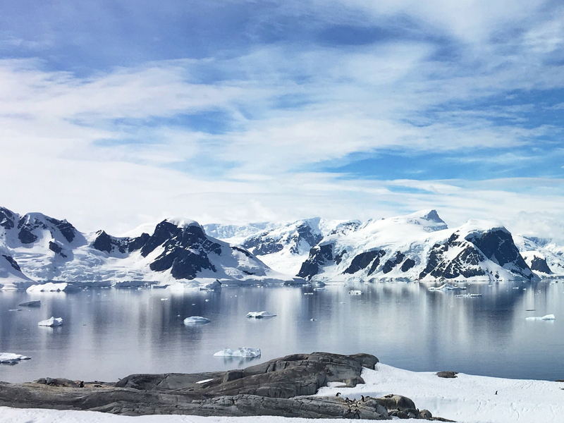 Snöklädda berg vid havet i Arktis