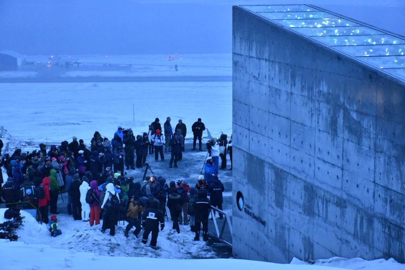 Människor står utanför fröbanken i Svalbard i snön