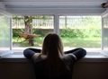  Young woman looking out of window