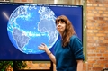 woman pointing at a photo of the globe